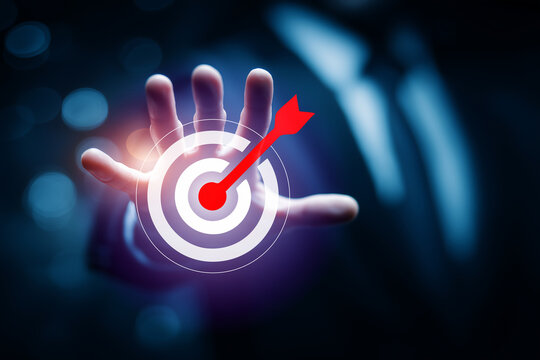 hand holding a dart on a target