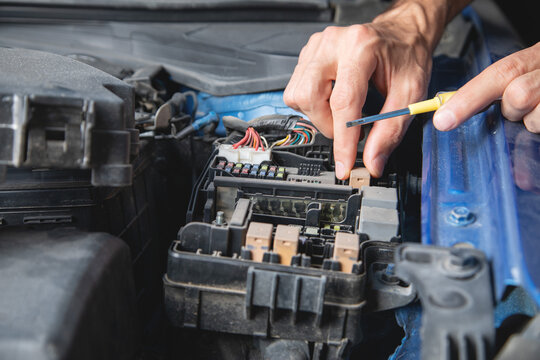 Technician checking car fuse. Car maintenance