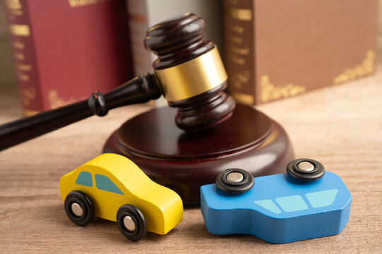 Car accident lawsuit and insurance, Judge hammer with car model.