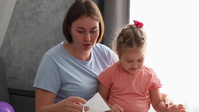 Mother and daughter enjoying creative drawing session while making greeting cards at home. Childhood development and artistic expression concept.