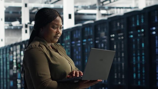 Worker runs equipment checkups in a data center, supporting system stability, equipment checkups, software updates and reliable server infrastructure management.