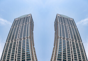 Fototapeta premium a digitally composed fine art architectural photograph created by mirroring and joining sections of a modern glass skyscraper