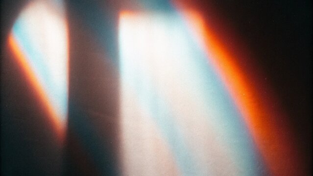 Holographic rainbow light leak overlay featuring iridescent prism reflections, glowing spectral streaks, cinematic film grain and dreamy optical flare, abstract futuristic background