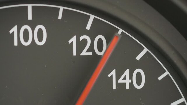 Macro shot of an analog car speedometer needle pointing at exactly 130 kmh, conceptualizing the discussed German Autobahn speed limit debate and climate policy