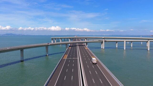Aerial drone view of Jiaozhou Bay Cross Sea Bridge in Qingdao, coastal traffic infrastructure over sea water，Drone shot of multi-level sea interchange bridge with moving vehicles, Jiaozhou Bay Qingdao