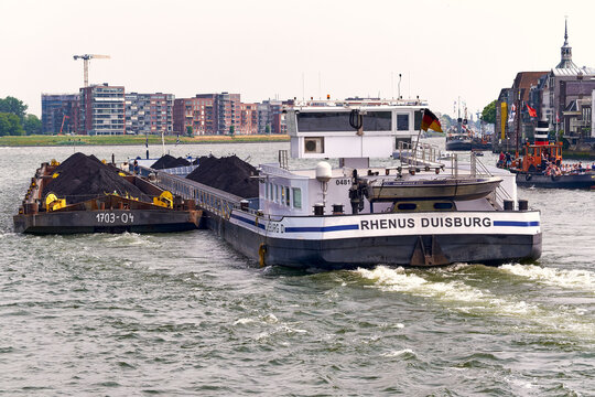 Inland shipping and cargo transport German coal vessel Rhenus Duisburg with tugged barges on the Merwede river in Dordrecht Netherlands supply chain