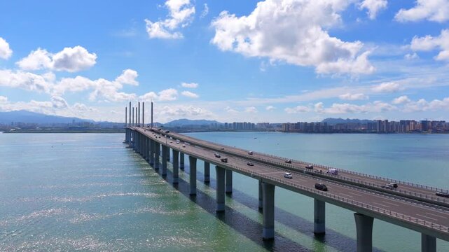 Coastal highway bridge spanning Jiaozhou Bay, Qingdao urban transportation landscape under cloudy sky