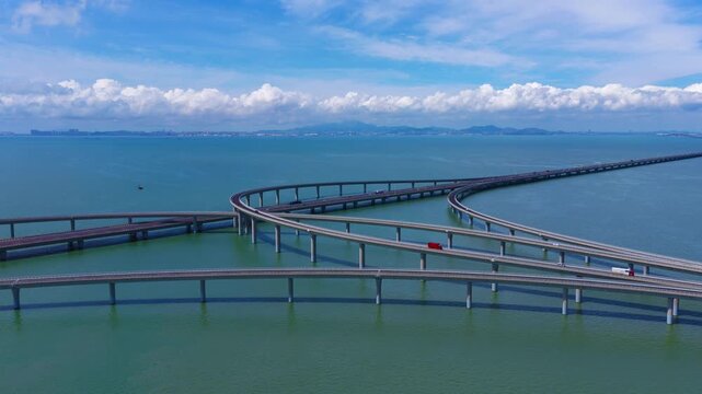 Aerial drone view of Jiaozhou Bay Cross Sea Bridge in Qingdao, coastal traffic infrastructure over sea water，Delayed aerial photography of traffic shuttling on a sea bridge