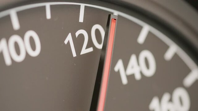 Macro shot of an analog car speedometer needle pointing at exactly 130 kmh, conceptualizing the discussed German Autobahn speed limit debate and climate policy