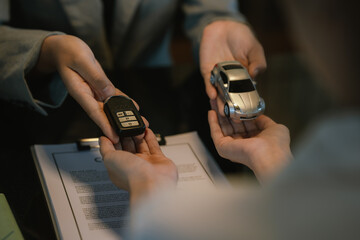 Fototapeta premium Professional car insurance or sales agreement signing with a toy car on the desk