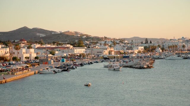 Golden hour view of a picturesque harbor lined with boats and traditional waterfront architecture in a Mediterranean coastal town