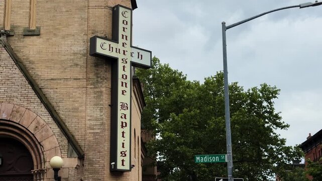Cornerstone Baptist Church exterior with cross sign and Madison St street sign visible