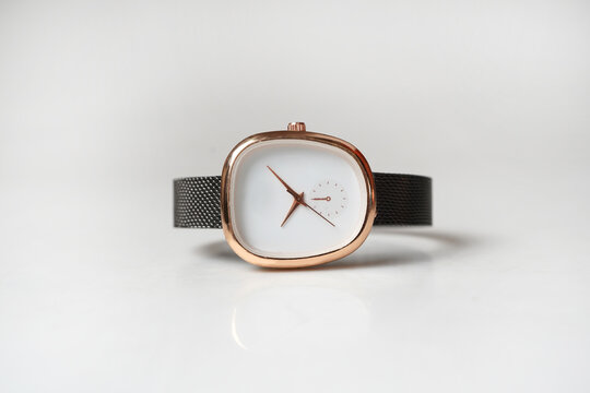 Elegant Rose Gold Oval Wristwatch with Black Mesh Strap isolated on White Background