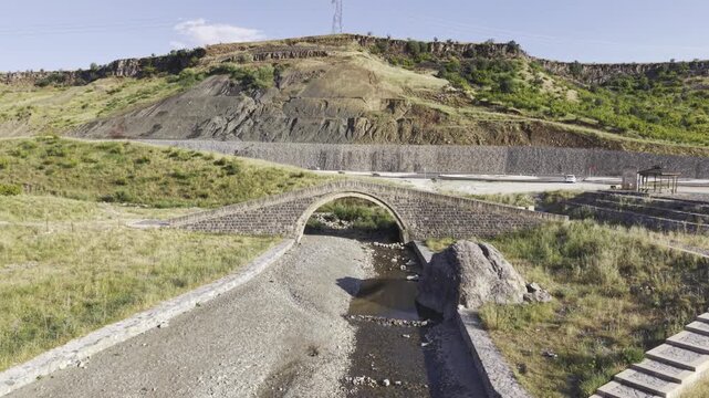 Cinematic View of Historic Kasrik Bridge in Siirt, Turkiye &ndash; Stone Arch Bridge Over Botan River and Anatolian Heritage