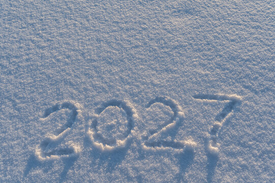 Seasons greetings 2027 words written by a finger in snow