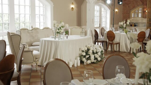 Wedding reception setup featuring elegant floral arrangements and seating, creating a beautiful ambiance for guests in a well-lit venue