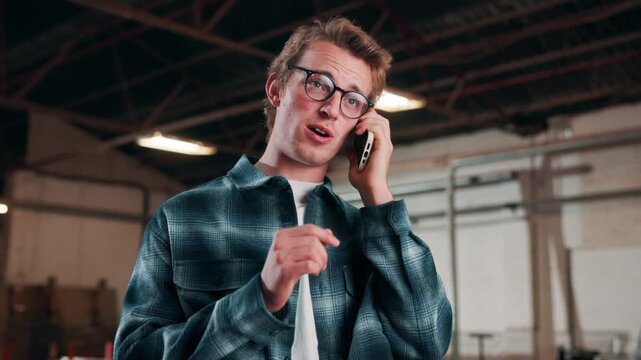 Phone call, carpenter and talk with man in warehouse for furniture order, client briefing and contact. Communication, joinery and manufacturing with person for inspection update and discussion