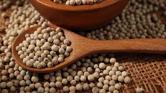 close-up of white pepper in a wooden spoon.