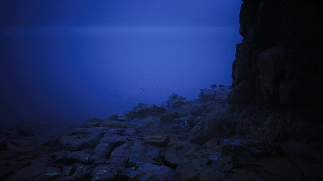 Mosaic of wet stones under midnight blue, scattered pebbles and slick rock form intricate foreground patterns, faint wave marks and shallow pools create subtle