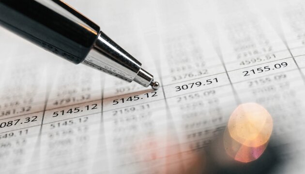 A ballpoint pen points to figures on a printed financial spreadsheet, useful for accounting, audit, budgeting, banking, or business reporting materials.