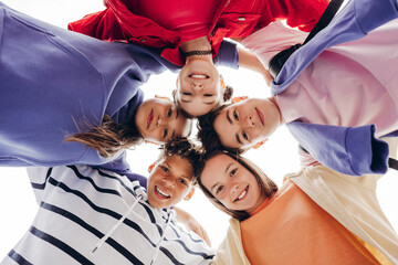 Close group of teenage friends looking down at camera in circle © Maria Vitkovska