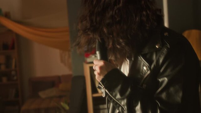 Man singing passionately into microphone and headbanging in home studio. Video for music school advertisements, creative lifestyle promos or hobbyist content