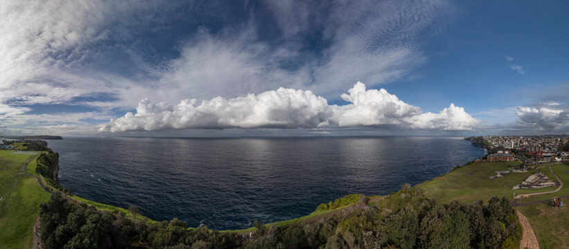 Panorama of Christison Park, Sydney with view of cliffs and storm clouds over the sea.