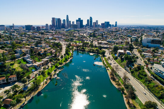 Aerial view of Echo Park Lake with the downtown Los Angeles skyline, surrounded by residential neighborhoods, palm trees, and urban roads in Los Angeles, California, United States.