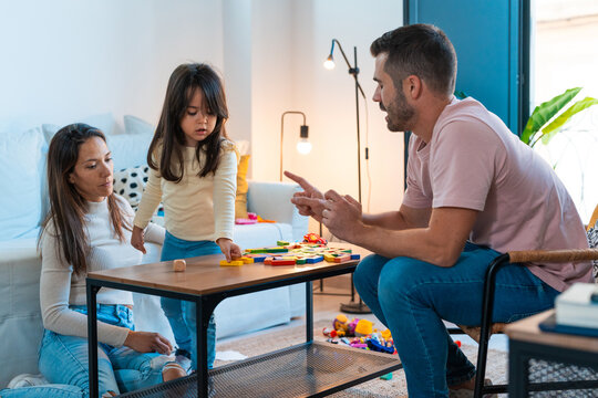 Father explain how to play building bricks to his daughter