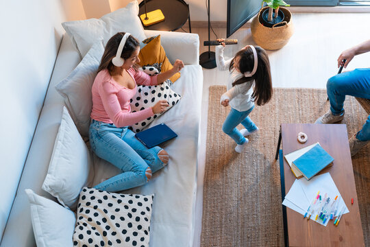 Mother and girl dancing listening to music at home