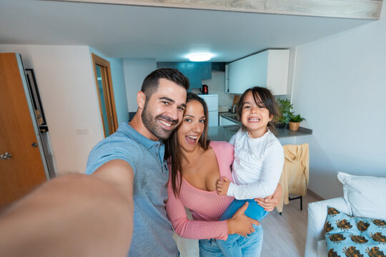 Happy family with one child taking a selfie at home