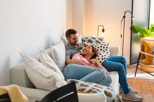 Couple watching tv lying together in the sofa
