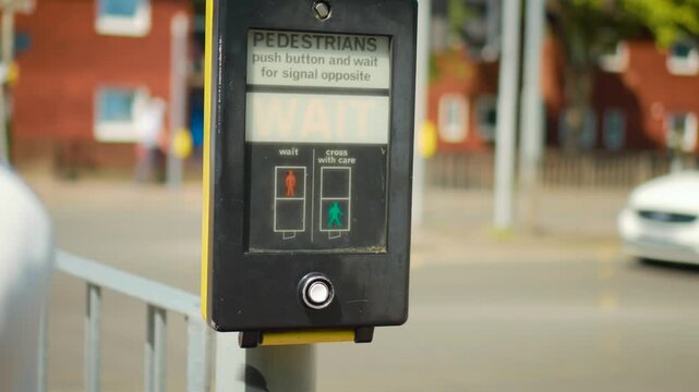 Traffic crossing request using pedestrian button at roadside signal control station. Hand pressing illuminated crosswalk panel with wait notification near moving city cars. Safe walking concept with