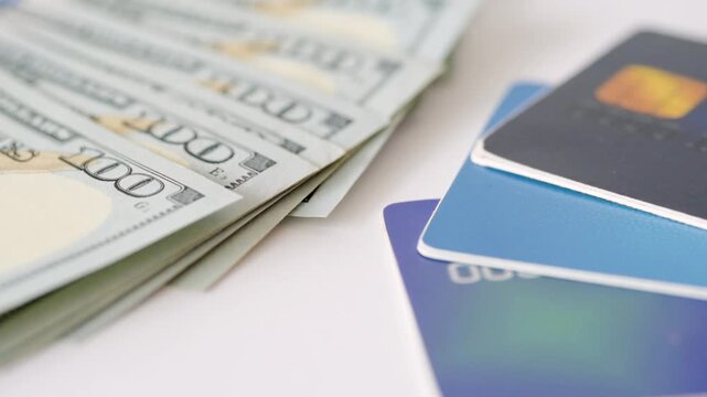 Closeup layered hundreddollar bills and cards illustrating ecommerce payout and digital wallet options, stacked blue cards with EMV chip, modern fintech aesthetic on white
