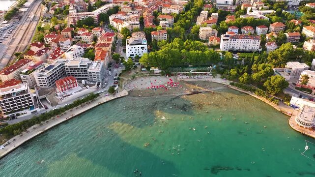 Split Croatia beach view with tourists and buildings near water
