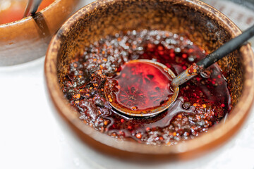 Fototapeta premium traditional chinese ceramic bowl filled with spicy red chili oil seasoning