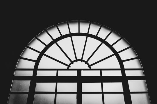 L'arco di una grossa porta a vetri in controluce in bianco e nero