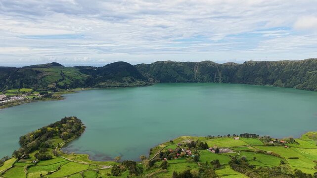 An aerial panoramic wide shot of the green volcanic crater lake Lagoa das Sete Cidades in image d02f18 jpg surrounded by lush green hills and valleys on Sao Miguel Island Azores Portugal Europe