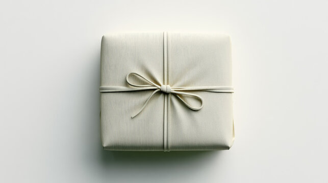Gift box wrapped parcel square package ribbon bow beige minimalist present top view plain background elegant simple wrapped gift square shape paper fabric textured soft shadow clean isolated