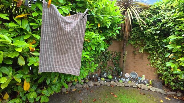White Towel Drying On Washing Line Blowing In Garden Wind Close Up