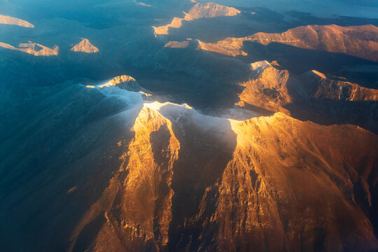 Twin Snowy Mountain Peaks Glowing in Sunrise Light from Above