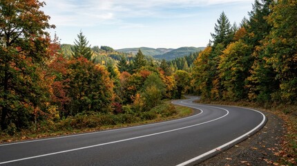 Naklejka premium Winding through a lush forest road during autumn season in a scenic mountain landscape