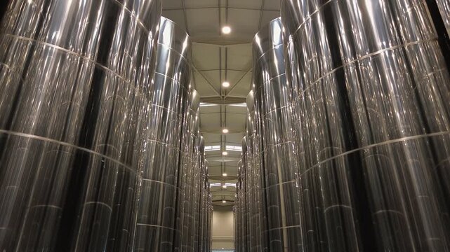 Symmetrical view of large stainless steel storage vats in a modern winery or beverage processing facility