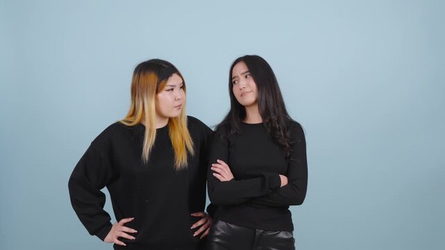 Disappointed asian women standing with crossed arms and looking annoyed