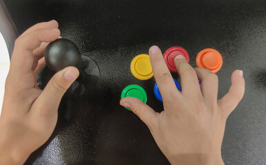 Child boy gamer pressing 6-button arcade controller © WH_Pics