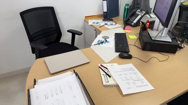 Empty office desk with business papers and computer