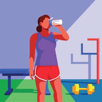 Person drinking water from bottle at gym with weights