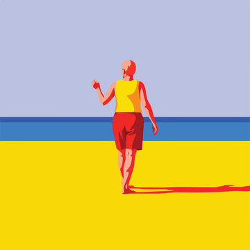 Person in yellow shirt and red shorts walks on a yellow beach next to blue water