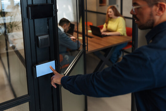 Man scanning access control panel entering modern office