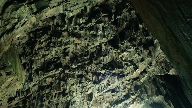 Slow moving shot of the rugged ceiling inside Cathedral Cavern in Little Langdale, highlighting dramatic rock formations, geological textures, and the vast scale of the historic underground chamber